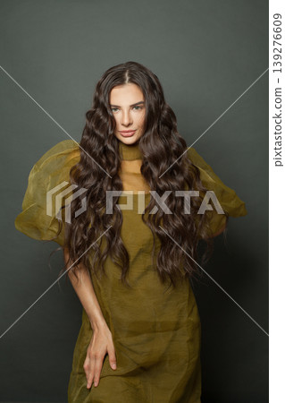 Cheerful woman hair. Beautiful model with long curly hairstyle posing Cheerful woman hair. Beautiful model with long curly hairstyle posing 139276609