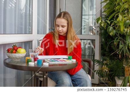 Smiling child drawing pink cats in a sketchbook. Young preteen girl painting 139276745