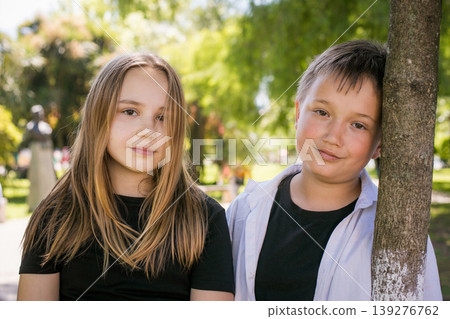 Happy young girl and boy together in park, outdoors portrait. Happy children Happy young girl and boy together in park, outdoors portrait. Happy children 139276762