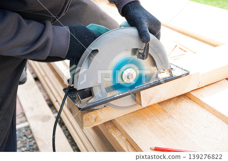 Carpenter man using circular saw to cut wooden plank Carpenter man using circular saw to cut wooden plank 139276822