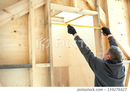 Professional unrecognizable constructor using ruler to check door frame. Professional unrecognizable constructor using ruler to check door frame. 139276827