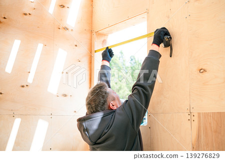 Professional unrecognizable constructor using ruler to measuring window frame 139276829