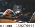 Man making secure online payment using smartphone and laptop with digital interface, concept of mobile banking, fintech, e-commerce transaction, and financial technology security. 139276944