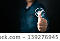 Man showing thumbs up with glowing digital check mark, representing approval, success, positive feedback, quality assurance, and business achievement concept with modern technology. 139276945