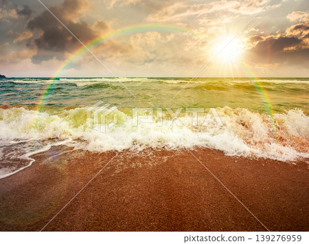 sunset over storm on the sandy beach. wonderful sea view with cloudy sky. salt water and crashing waves. view of bulgaria beach in summer. wind weather background under rainbow sunset over storm on the sandy beach. wonderful sea view with cloudy sky. salt water and crashing waves. view of bulgaria beach in summer. wind weather background under rainbow 139276959