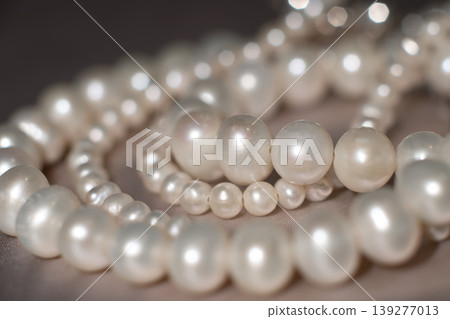 Elegant pearl strands arranged on neutral background, symbol of luxury and refinement. 139277013