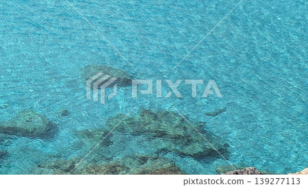 Blue sea water with small rocks in the foreground on Comino island Blue sea water with small rocks in the foreground on Comino island 139277113