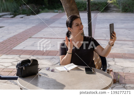 Woman Video Calling on Smartphone in Cafe. 139277271
