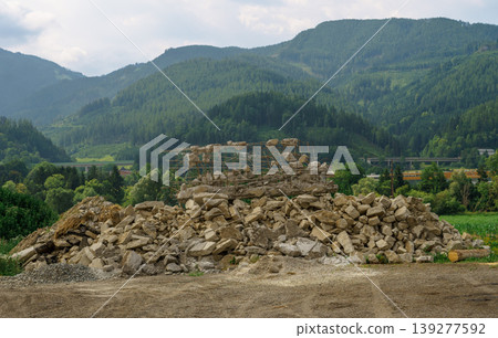 Pile of stones and rubble from old building material against the backdrop of the Alps Pile of stones and rubble from old building material against the backdrop of the Alps 139277592