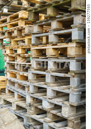Many used wooden pallet stacks on a construction site. Warehouse materials 139277593