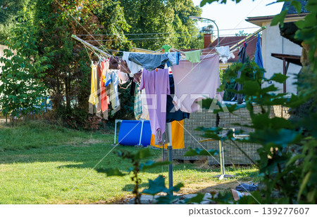 Various clothes drying outside after washing on an umbrella dryer Various clothes drying outside after washing on an umbrella dryer 139277607