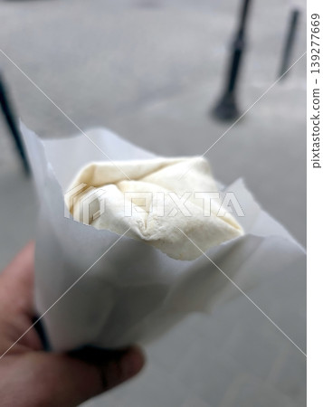 Delicious Doner Kebab Wrapped in Paper Held by a Person on a City Street Delicious Doner Kebab Wrapped in Paper Held by a Person on a City Street 139277669