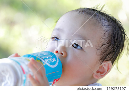 Close-up of a toddler's face while drinking water (vertical view) Close-up of a toddler's face while drinking water (vertical view) 139278197