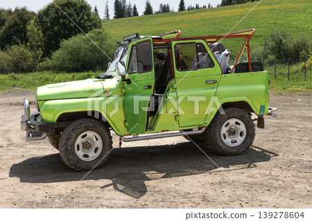 Bright green offroad vehicle parked on a dusty rural track Bright green offroad vehicle parked on a dusty rural track 139278604
