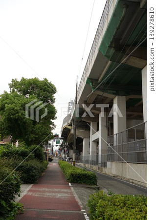 A view of a straight pedestrian walkway under a highway overpass. A view of a straight pedestrian walkway under a highway overpass. 139278610