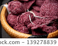 Soft burgundy yarn balls with knitting needles in basket 139278839
