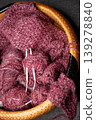 Soft burgundy yarn balls with knitting needles in basket 139278840