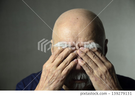 A bearded old man covering his face with his hands A bearded old man covering his face with his hands 139279131
