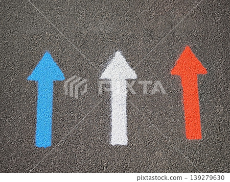Three multi-colored arrows on gray asphalt: blue, white and red Three multi-colored arrows on gray asphalt: blue, white and red 139279630