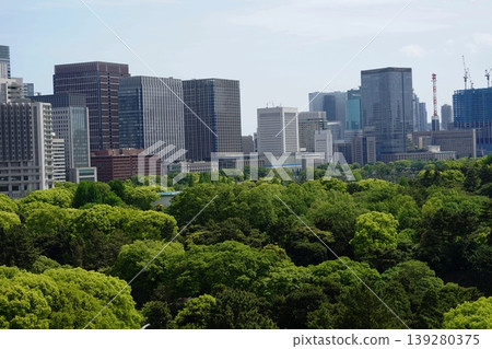 The lush greenery of the Imperial Palace grounds and the cluster of skyscrapers, April, Chiyoda 1185. Imperial Palace and skyscrapers. The lush greenery of the Imperial Palace grounds and the cluster of skyscrapers, April, Chiyoda 1185. Imperial Palace and skyscrapers. 139280375
