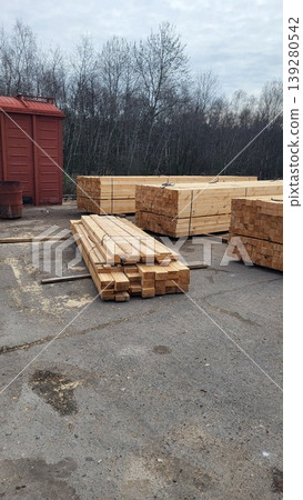 Stacked wooden planks in an industrial lumber yard, building materials storage, forestry industry logistics 139280542
