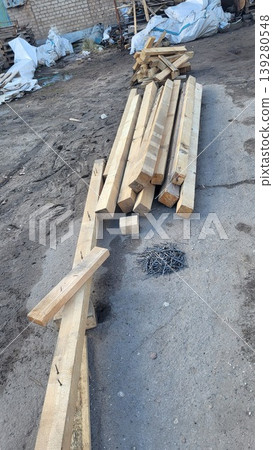 Scattered wooden planks and building debris on an industrial construction ground, site cleanup, work process Scattered wooden planks and building debris on an industrial construction ground, site cleanup, work process 139280548