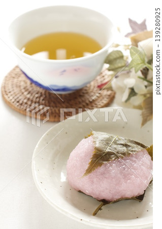 白盤上盛著櫻花年糕和日本茶。 白盤上盛著櫻花年糕和日本茶。 139280925