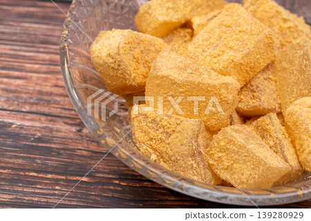 Close-up of a glass bowl of kinako mochi served on a wooden stand. Close-up of a glass bowl of kinako mochi served on a wooden stand. 139280929