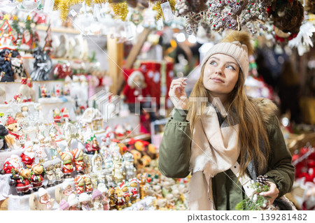 Young woman looking at decorated shop windows in the market Young woman looking at decorated shop windows in the market 139281482