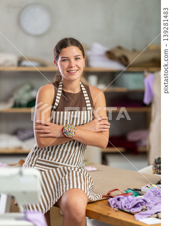 Portrait of positive female tailor in sewing workshop Portrait of positive female tailor in sewing workshop 139281483