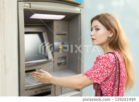 Young woman carefully entering pin code at atm Young woman carefully entering pin code at atm 139281490