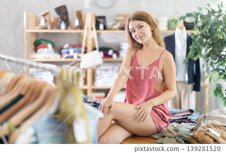 Sexy girl is sitting on table in sales area of store 139281520