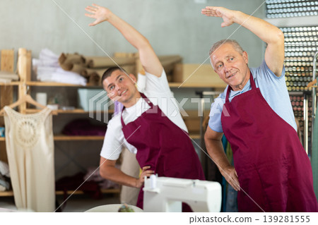 Male tailors doing a warm-up at work Male tailors doing a warm-up at work 139281555