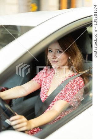 Positive young adult woman driving car during solo trip Positive young adult woman driving car during solo trip 139281574
