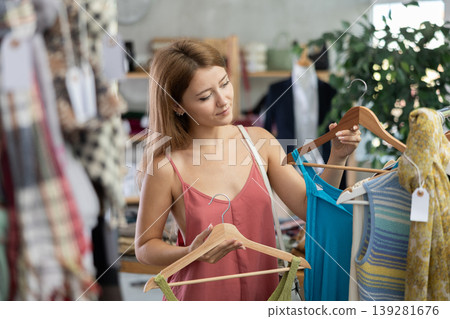 Girl customer choose tank top in store Girl customer choose tank top in store 139281676