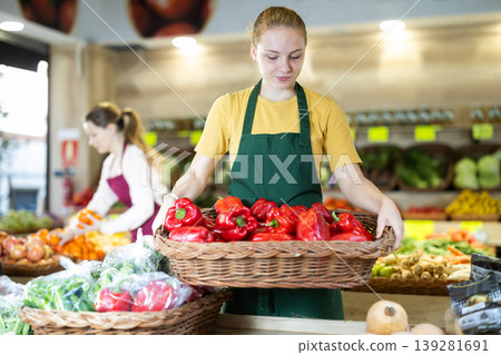 Girl employees in uniform holding bell pepper in grocery shop 139281691