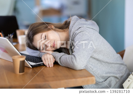 Tired woman sleeping in the office with her head on table 139281710