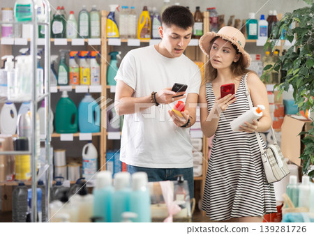 Couple scanning sunscreen on phone Couple scanning sunscreen on phone 139281726