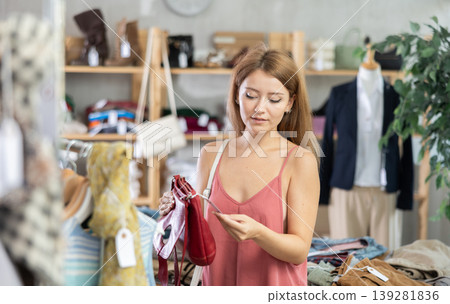 Woman choosing a handbag in a store Woman choosing a handbag in a store 139281836