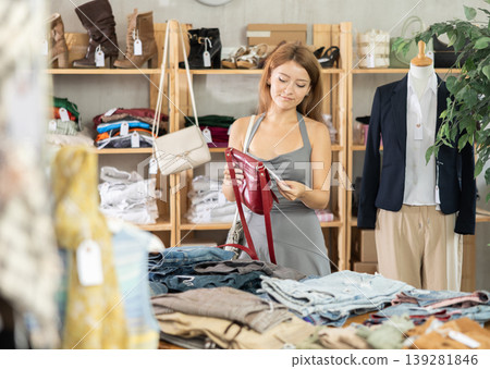 Woman choosing a handbag in a store Woman choosing a handbag in a store 139281846