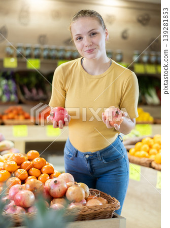 Teenage girl chooses pomegranates in store Teenage girl chooses pomegranates in store 139281853