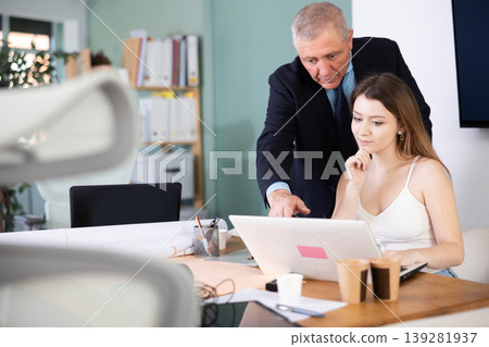 Elderly man help young woman with laptop Elderly man help young woman with laptop 139281937