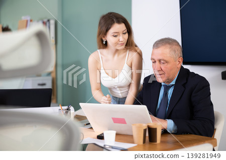 Young woman help elderly man with laptop Young woman help elderly man with laptop 139281949