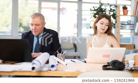 Elderly man and young woman working in office Elderly man and young woman working in office 139281966