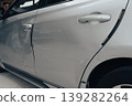 Silver car door with visible scratches and dents close-up 139282264