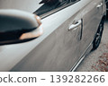 Close-up of damaged white car door with dent and scratch 139282266