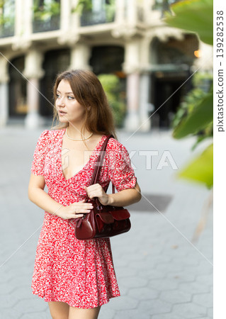 Woman in dress looking around city street on summer day 139282538
