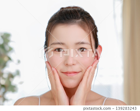 一位容貌自然的日本女性在護膚時輕撫臉頰（美麗肌膚/化妝品） 139283243