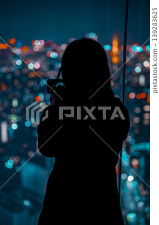 A woman gazing at the night view from the observation deck of Shibuya Sky. A woman gazing at the night view from the observation deck of Shibuya Sky. 139283625