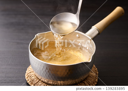 用湯匙舀起滾燙的高湯。 139283895